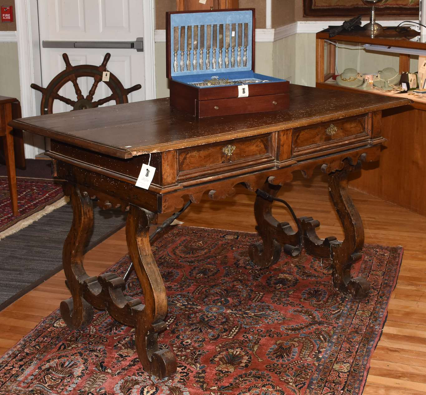 Early Spanish walnut two-drawer trestle table, with iron stretcher, 55”L. x 34.5”H. x 29”W.